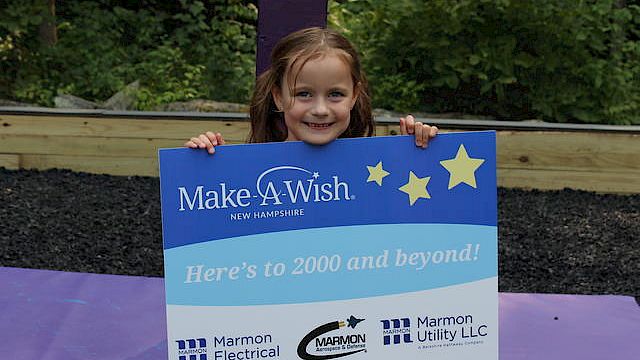 A smiling child holds a "Make-A-Wish New Hampshire" sign, indicating support from Marmon Electrical and Marmon Utility LLC.