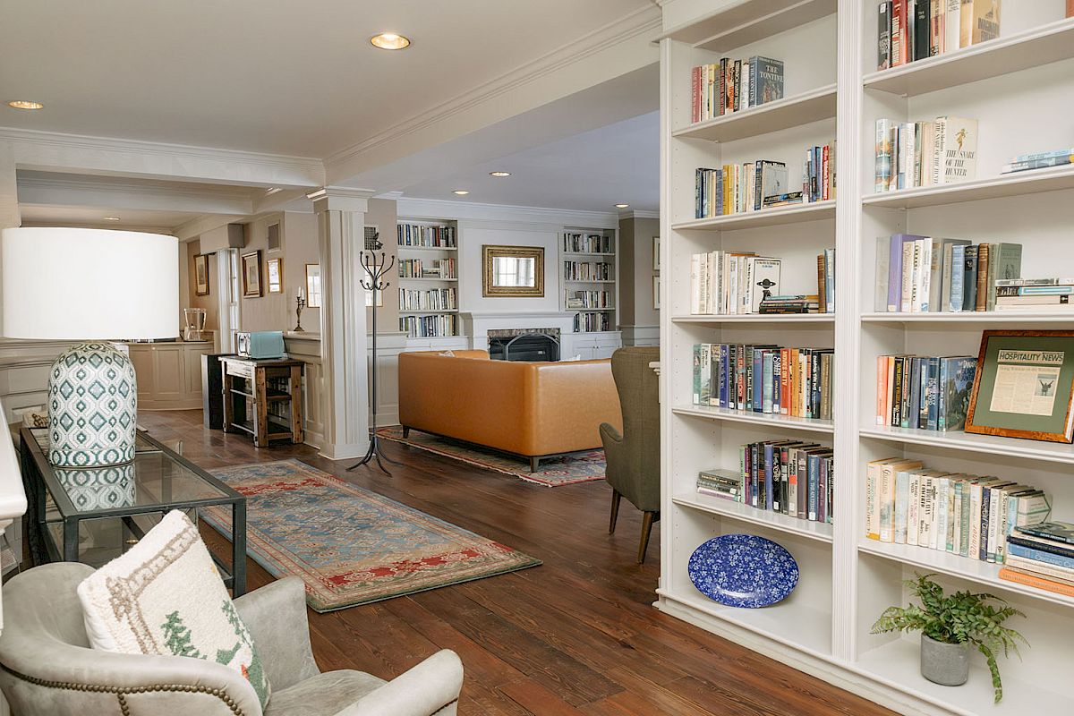 Cozy, well-lit living room and library with built-in bookshelves, a fireplace area, and comfortable seating in a warm, inviting home.